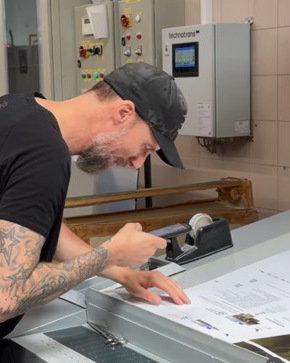 LONGO S.p.A.: un operatore verifica un foglio stampato con la lente